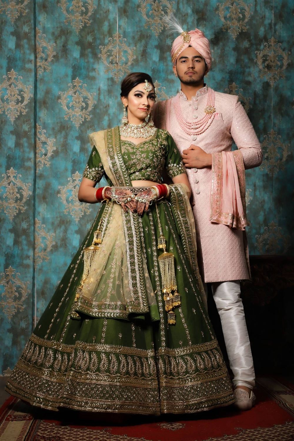 Bridal lehenga in green with gold embroidery and a matching sherwani