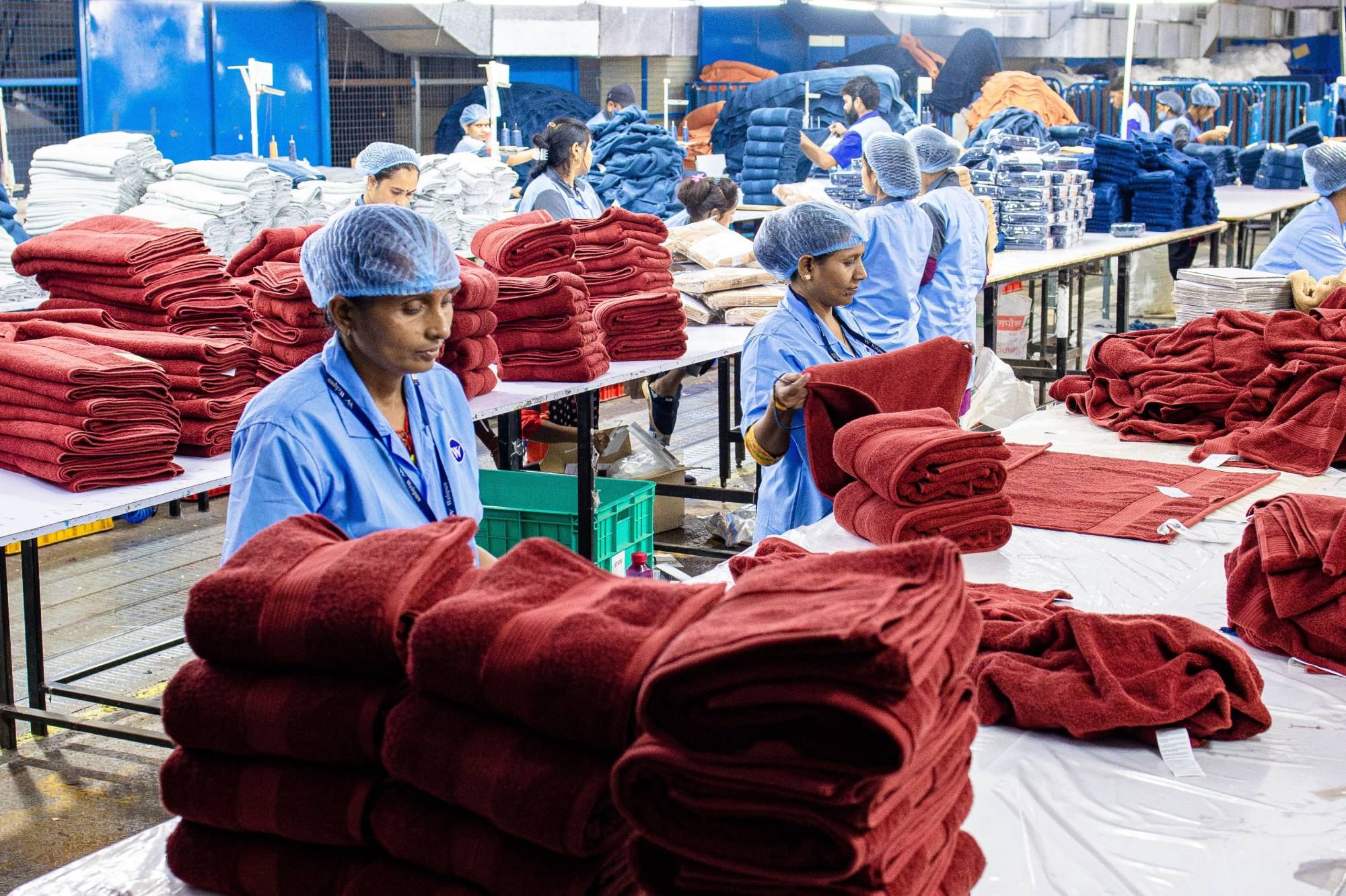 Folded red cotton towels being packed