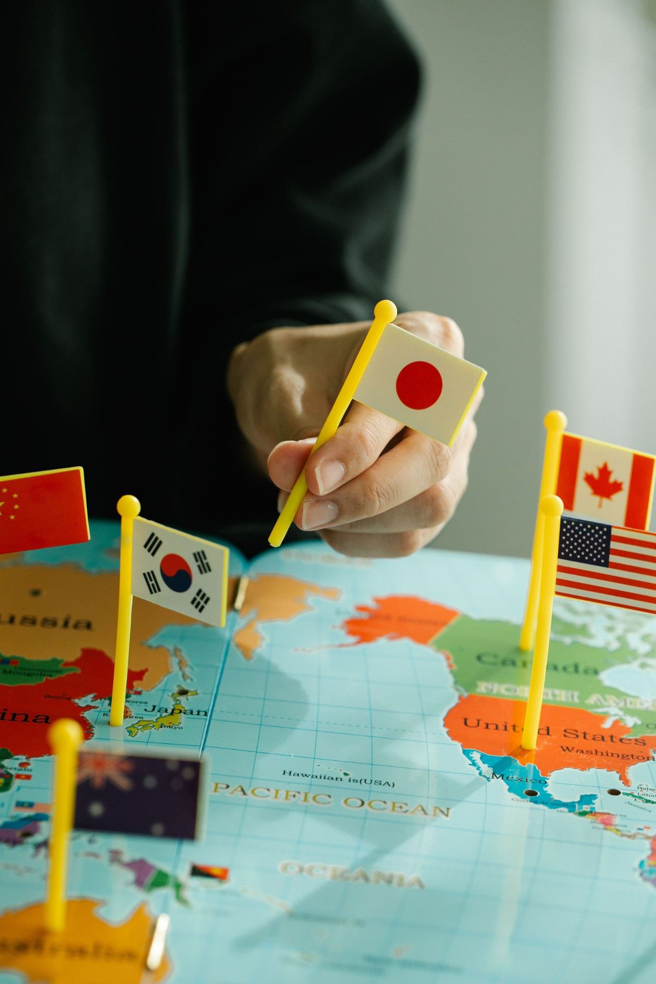 Hand placing country flags on a world map